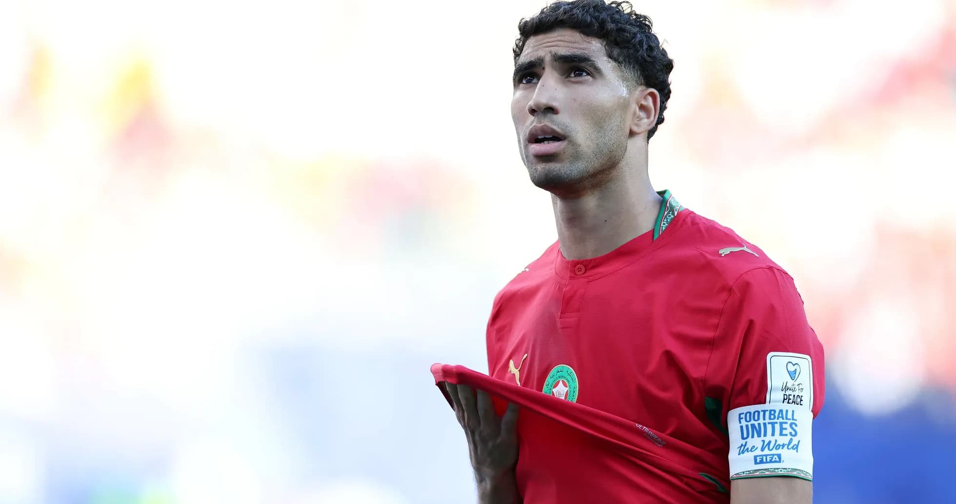 Jugador de Marruecos sosteniendo su camiseta en el campo Jugador de Marruecos sosteniendo su camiseta en el campo