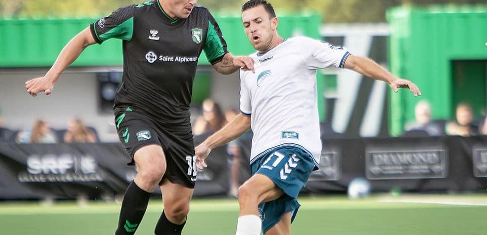 Jugadores compitiendo por el balón en el partido Jugadores compitiendo por el balón en el partido