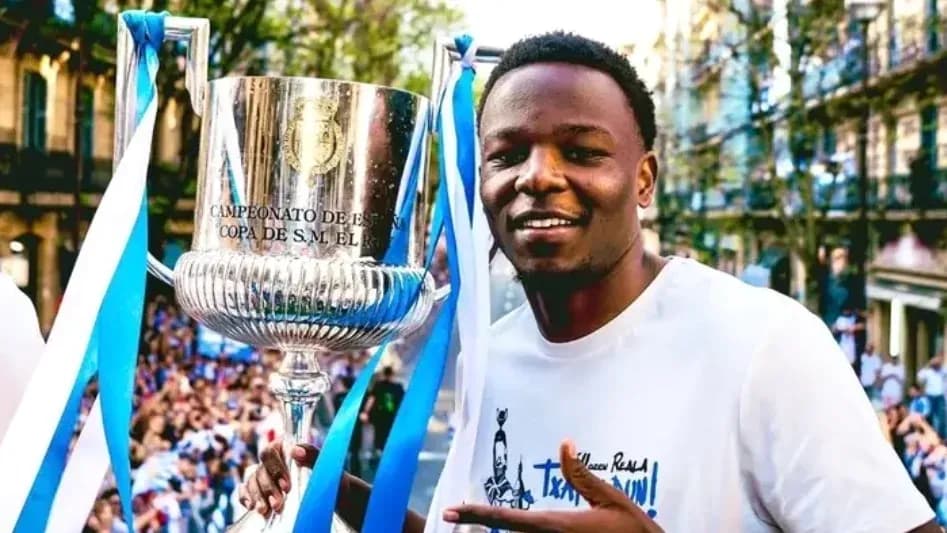 Jugador sosteniendo la copa de campeón en celebración Jugador sosteniendo la copa de campeón en celebración