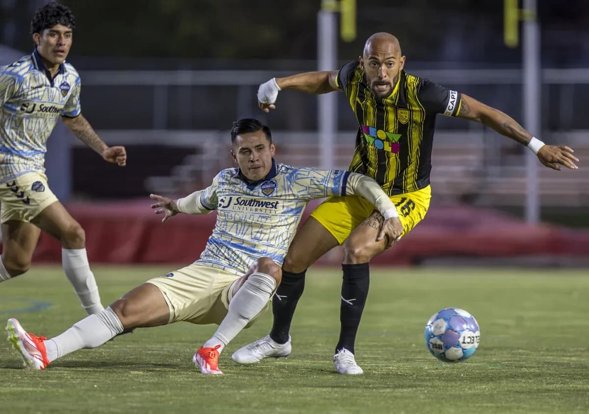 Jugadores compiten por el balón en el partido Jugadores compiten por el balón en el partido