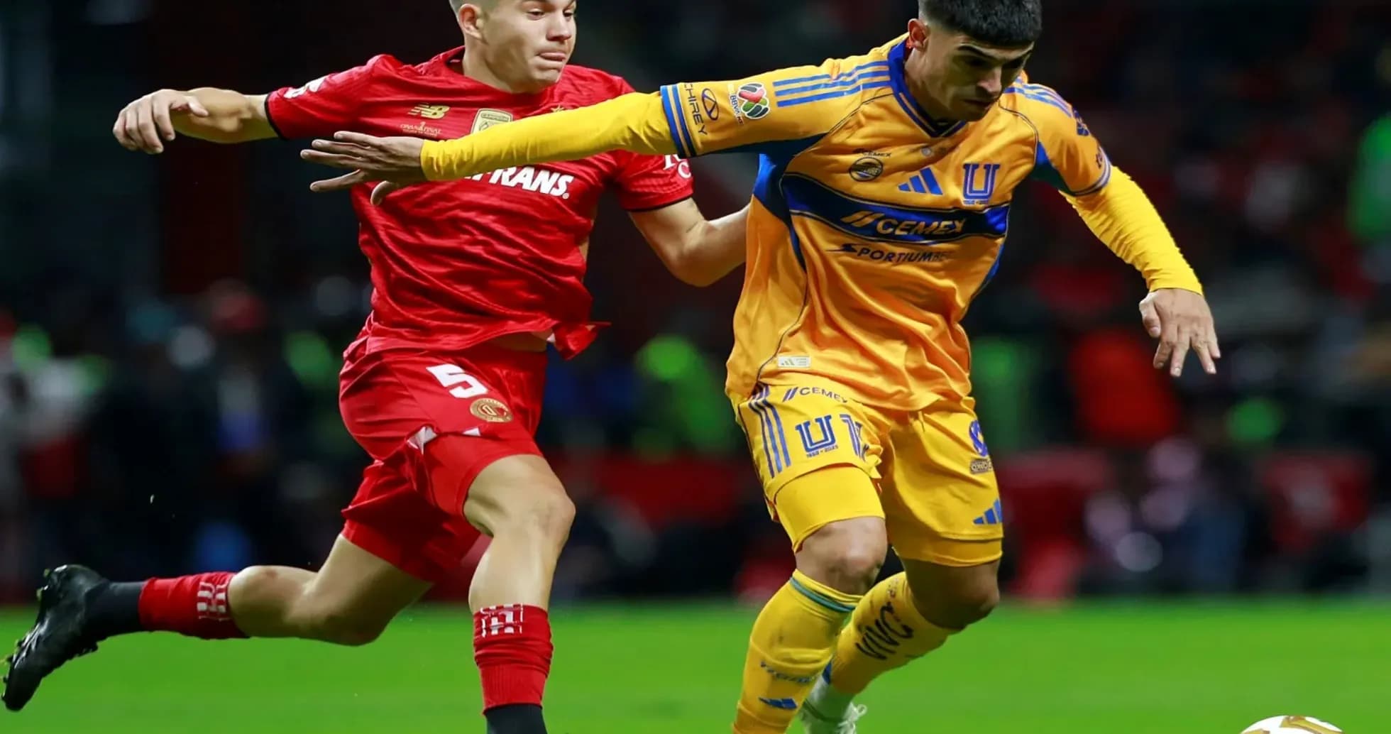 Jugadores de Toluca y Tigres compitiendo por el balón Jugadores de Toluca y Tigres compitiendo por el balón