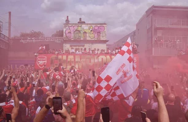 Aficionados celebrando el campeonato de Arsenal con humo Aficionados celebrando el campeonato de Arsenal con humo