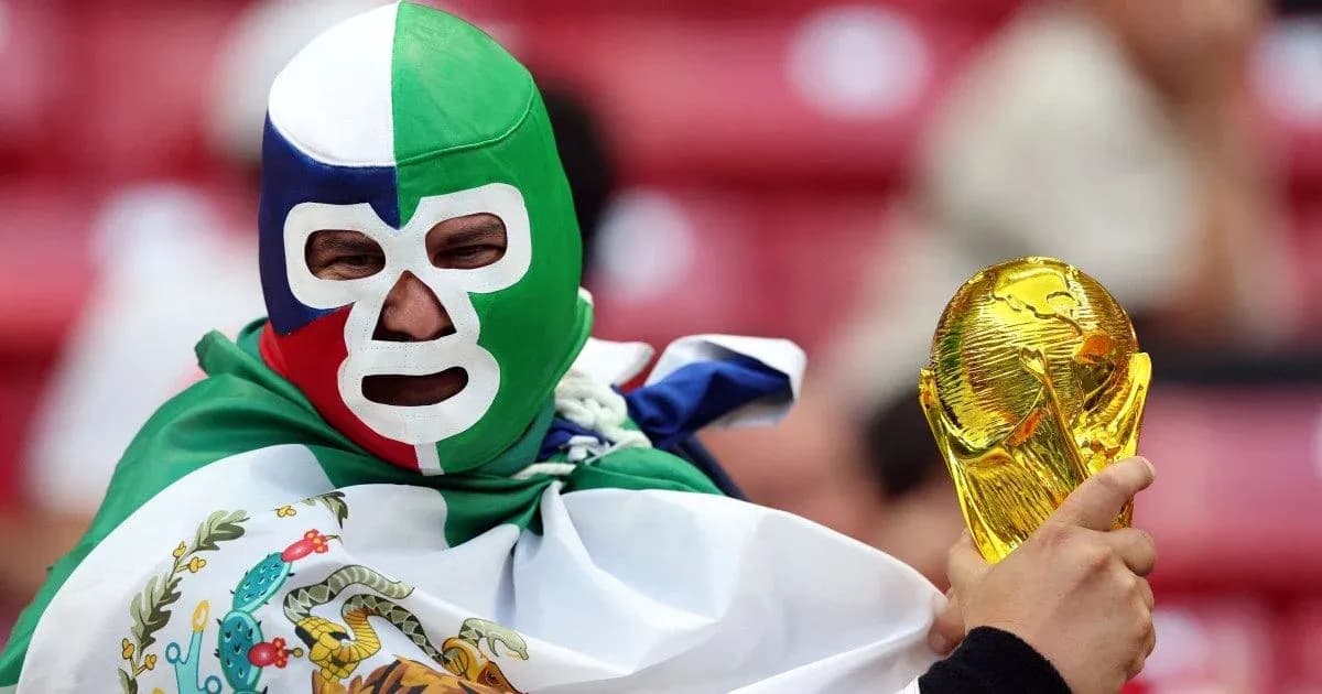A fan wearing a mask holding the World Cup trophy A fan wearing a mask holding the World Cup trophy