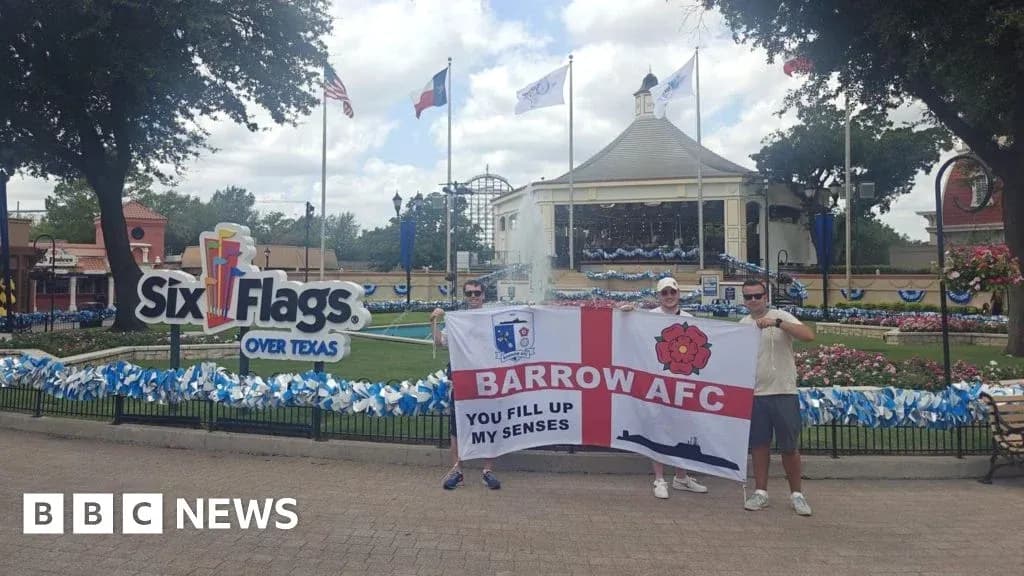 Dos personas sosteniendo una bandera de Barrow AFC en Six Flags Dos personas sosteniendo una bandera de Barrow AFC en Six Flags