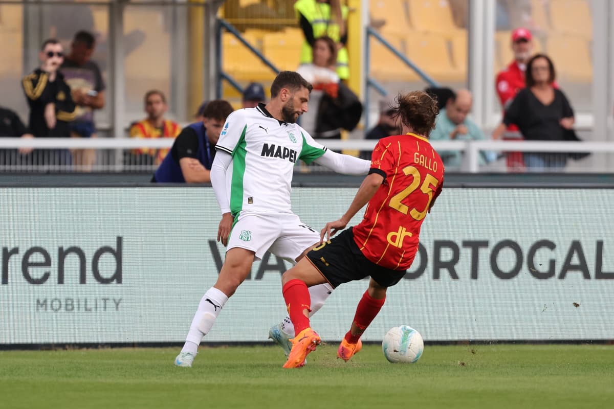 Jugador de Sassuolo desafiando a Gallo de Lecce Jugador de Sassuolo desafiando a Gallo de Lecce