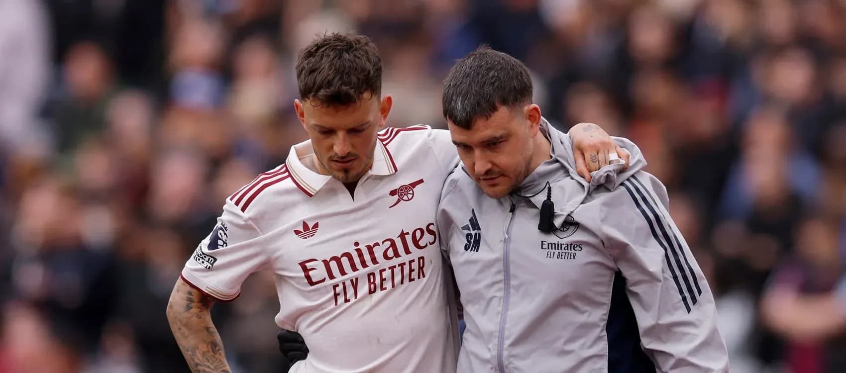 Jugador de Arsenal siendo ayudado por personal médico Jugador de Arsenal siendo ayudado por personal médico