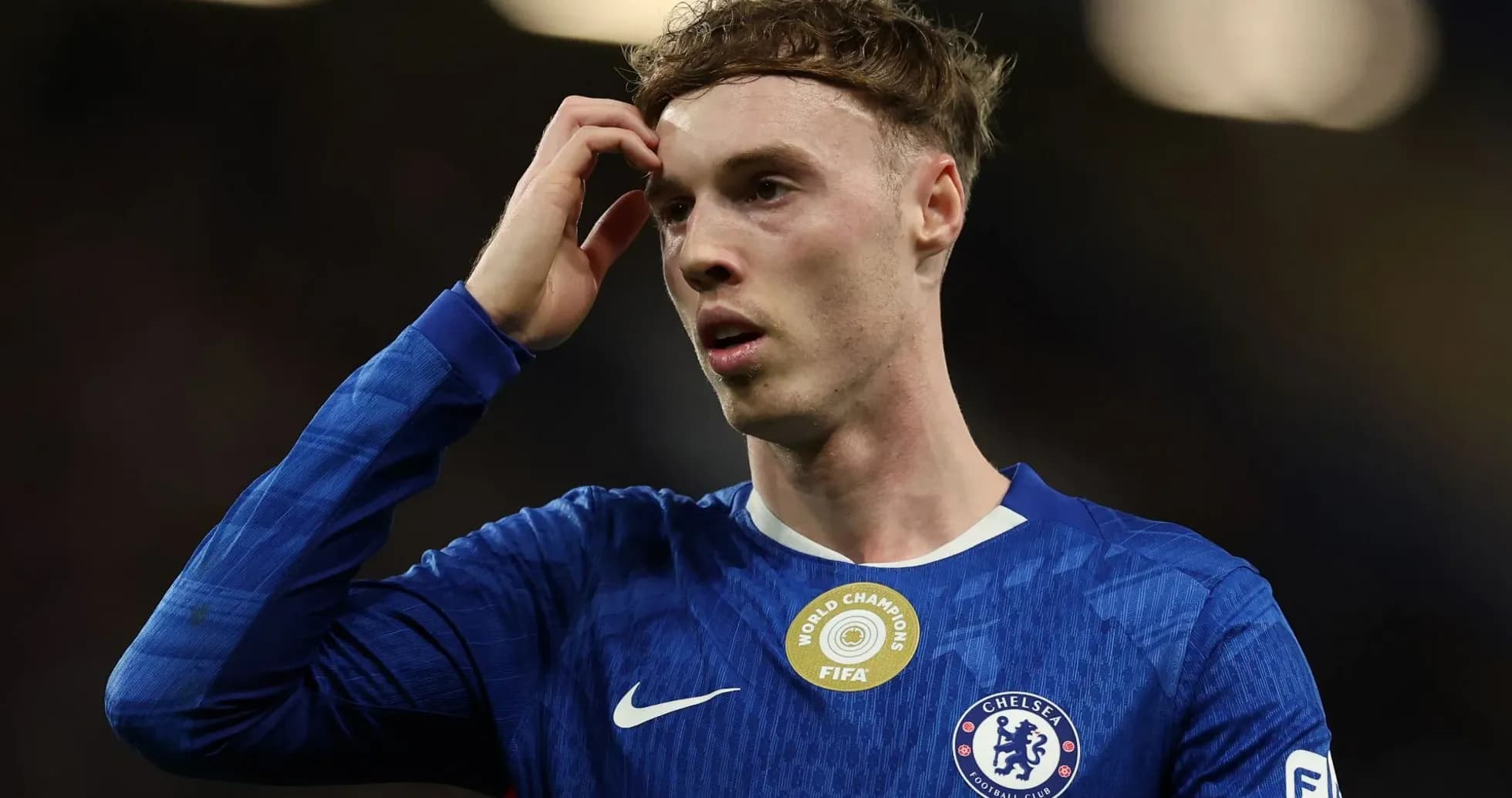 Jugador de Chelsea con camiseta azul, tocándose la cabeza Jugador de Chelsea con camiseta azul, tocándose la cabeza
