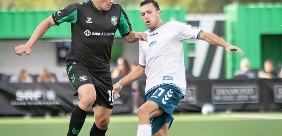 Dos jugadores compitiendo por el balón en el partido Dos jugadores compitiendo por el balón en el partido