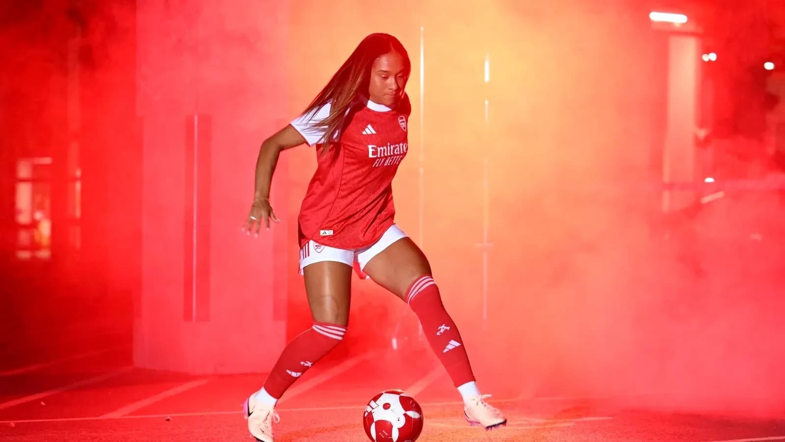 Jugadora de fútbol en acción con humo rojo Jugadora de fútbol en acción con humo rojo